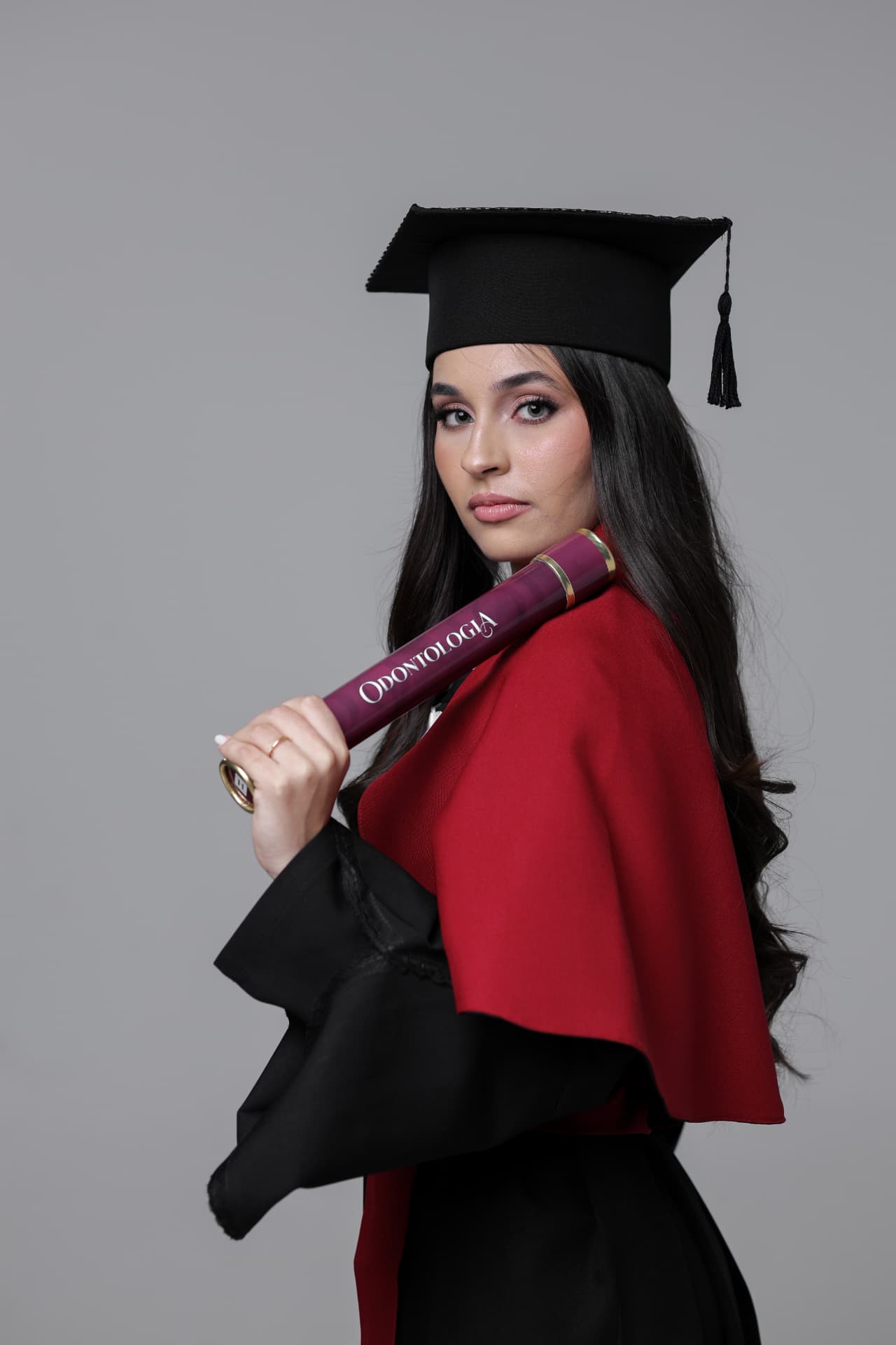 Bianca Zanelato formada em Odontologia, segurando o diploma